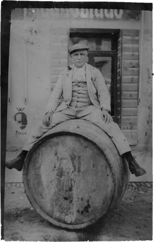 Foto storica di Gino Benedetti, il fondatore di Benedetti Liquori, a cavalcioni su una botte di liquore artigianale di produzione propria.