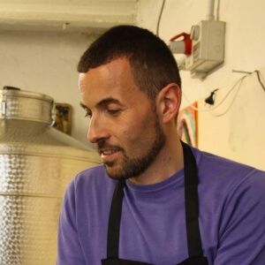 Ritratto di Luca Valbusa nel laboratorio del liquorificio artigianale.